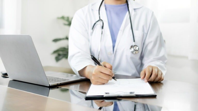 The female doctor sat and checked the patient's history and used