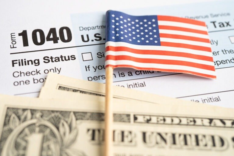 Tax Return form 1040 with USA America flag and dollar banknote,